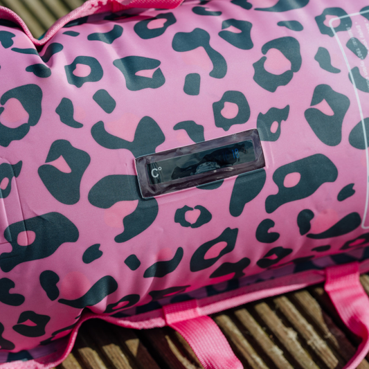 Pink inflated tow float with black leopard print pattern on a wooden surface