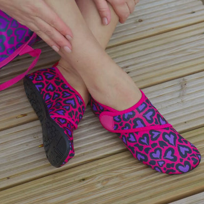 Video of woman wearing pink leopard print neoprene beach shoes and removing them with the velcro ankle strap